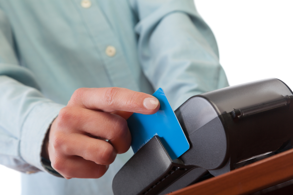 Human hand with credit card swipe through terminal for sale. Restorative Dentistry Gurnee